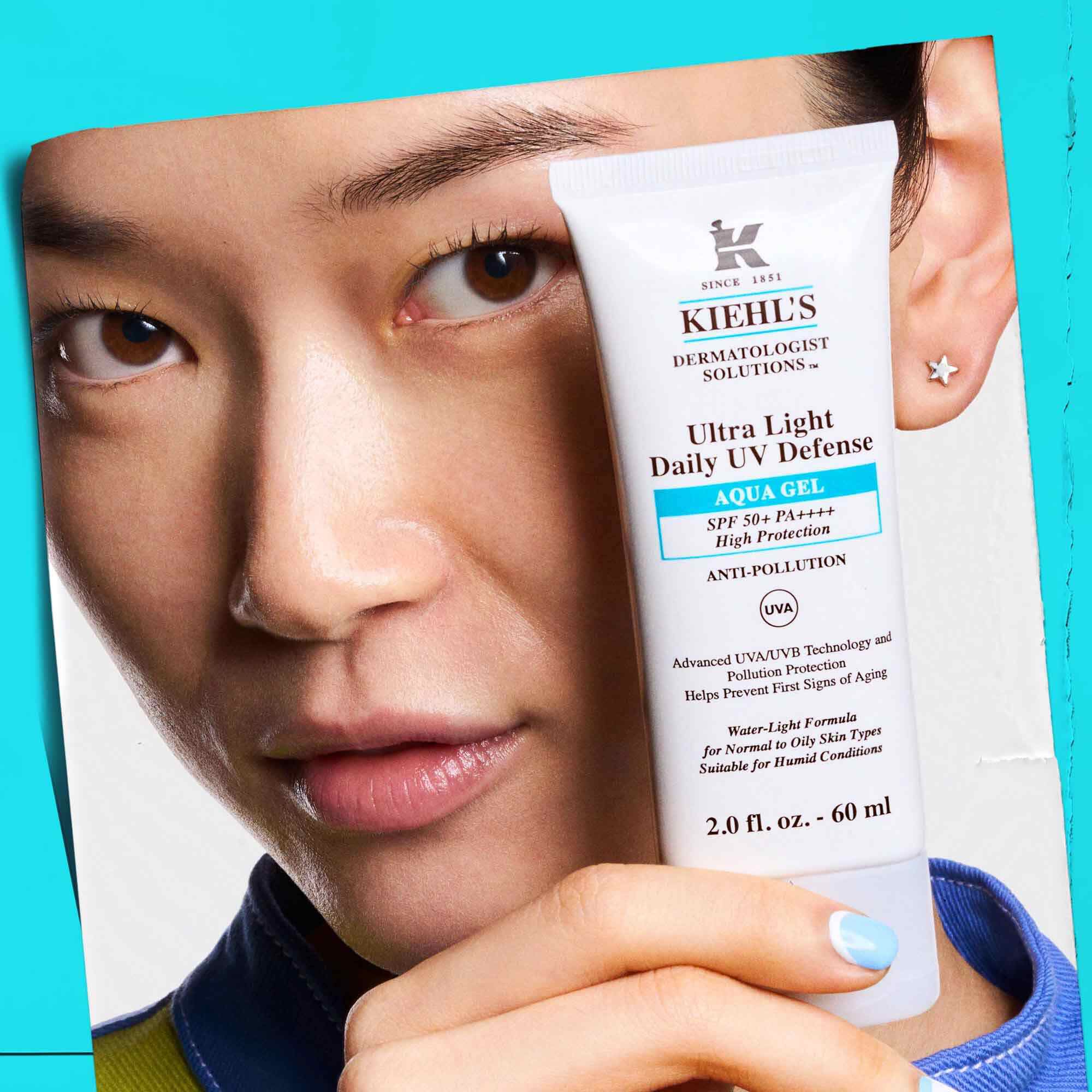 Un mannequin tenant un tube d'Ultra Light Daily UV Defense Aqua Gel, illustrant sa portabilite et sa facilite d'utilisation.