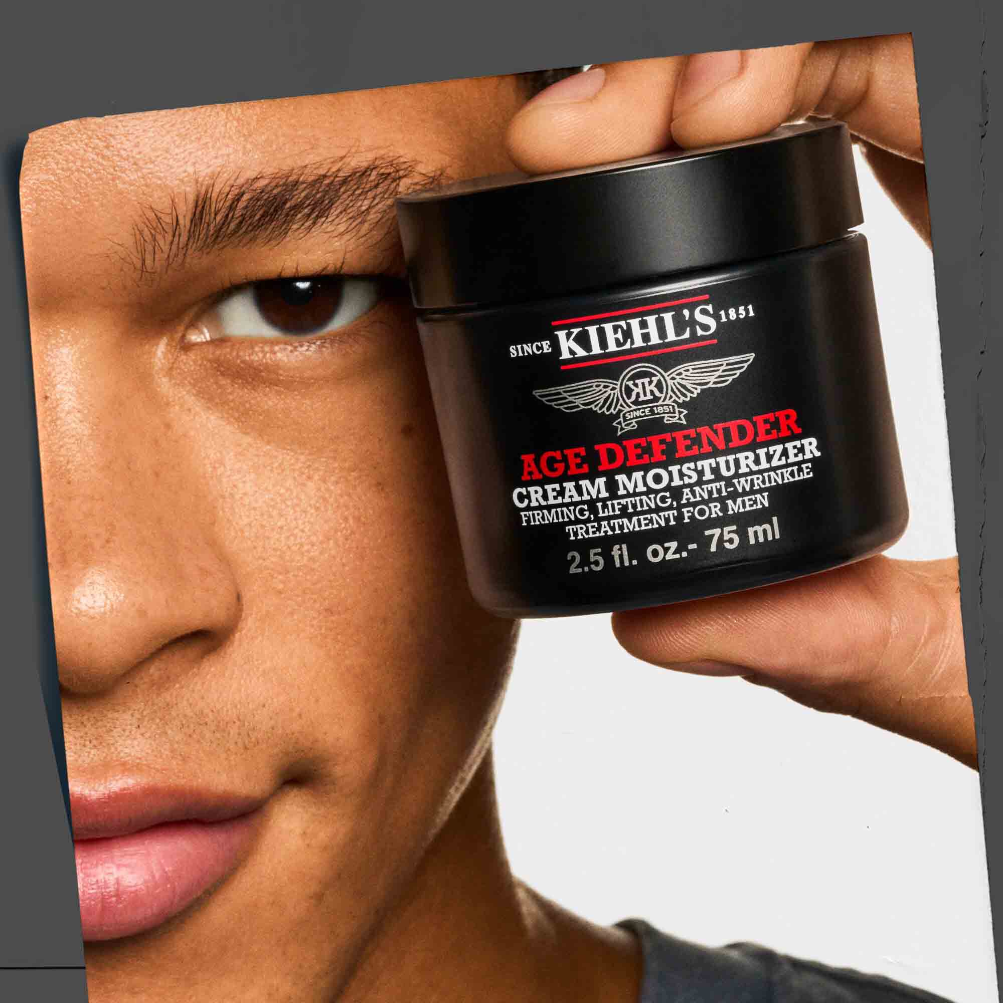 Creme hydratante Age Defender tenue a la main, illustrant son format pratique et sa facilite d'utilisation.