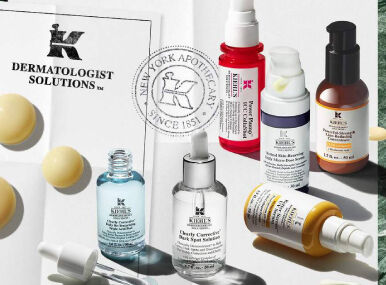 Plusieurs serums kiehl's de couleurs rose, violet, jaune, bleu marron poses sur un fond blanc.