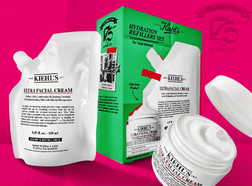 un coffret cadeau vert kiehl's avec des produits blancs sur fond rose