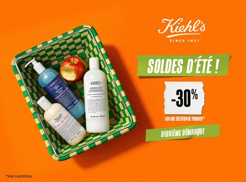 un panier vert et jaune avec a l'interieur une pomme et trois produits de soin de la peau kiehl's sur un fond orange