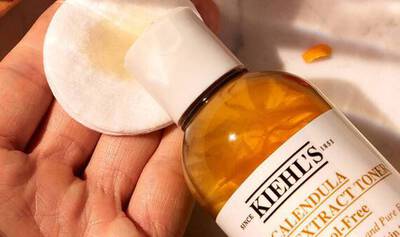 Application du Kiehl´s Calendula Herbal-Extract Toner sur un coton.
