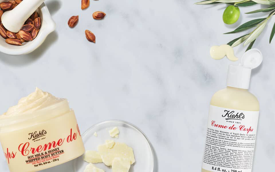 Kiehl's Creme de Corps – Beurre corporel fouette Soy Milk & Honey et lotion hydratante corps, enrichis en huile d'olive et beurre de karite, sur fond marbre blanc