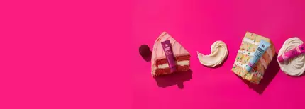 deux baumes a levres roses et un baume a levres bleu, poses sur un fond rose avec des parts de cake et de la creme glacee.