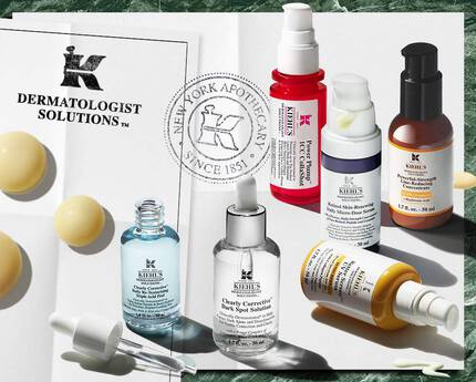 Gamme de soins Kiehl’s Dermatologist Solutions presentee sur un fond en marbre vert et papier blanc, avec plusieurs serums et cremes pour le visage, ainsi qu’une feuille ou il est ecrit « no appointment needed ». Un tampon « New York Apothecary Since 1851 » est egalement visible a droite.