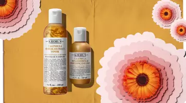 Deux fleurs jaunes de souci sur un fond marbre, avec des petales et un flacon en verre a cote, ainsi que le logo de Kiehl's.