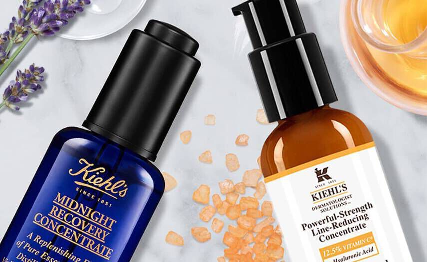 Deux flacons de serum de la marque Kiehl's, l'un pour la recuperation nocturne et l'autre pour reduire les rides, entoures de fleurs de lavande et de cristaux de sel.