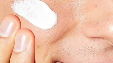 Un gros plan d'un visage avec une creme appliquee sur la joue.