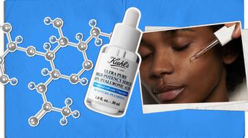 Une loupe sur une surface en metal, entouree d'un flacon, d'un tube a essai, de billes et d'une pince.